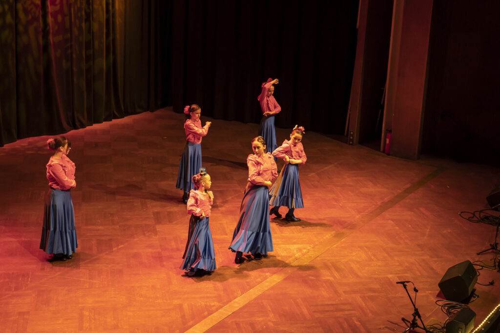 6 Flamenco-Tänzerinnen auf einer Bühne.