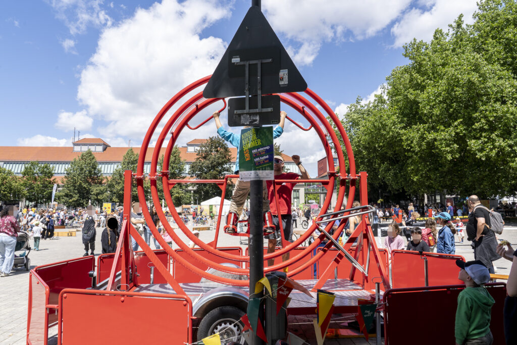 Ein 3D-Flieger in der Mitte des Bildes. Ein Jugendlicher ist dort eingespannt und kann mit seiner Körperbewegung die Richtung bestimmen.